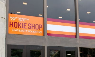 The exterior of the University Bookstore has large windows with orange and maroon stripes. White and maroon text says, "Hokieshop University Bookstore"